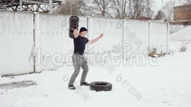举重运动员用手举起一大块重物，人在冬天做交叉训练